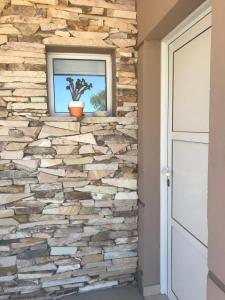 un muro in finta pietra in una casa con una finestra di Casa Brava a Puerto Pirámides