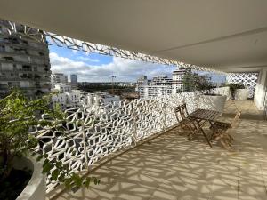 a balcony with two chairs and a white fence at Tour Végétale CFC Anfa Luxury in Casablanca