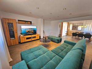a living room with a green couch and a television at Apartman Rio de Mar in Bibinje