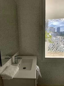 a bathroom with a white sink and a window at Tour Végétale CFC Anfa Luxury in Casablanca