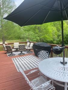 un patio con mesa, sillas y sombrilla en Branson Country B&B en Hermann
