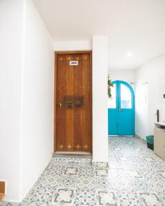 a hallway with a wooden door and a tile floor at Aldea Bella Boutique in Doradal