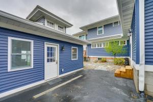 ein blaues Haus mit einer weißen Tür in einer Einfahrt in der Unterkunft Cozy Riverfront Michigan Studio with Fire Pit! in Marysville