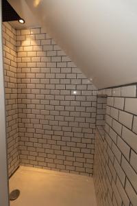 a walk in shower with white brick walls at Le paille en queue in Sainte-Mère-Église