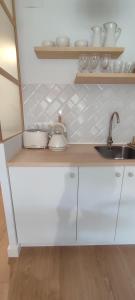 a white kitchen with a sink and a counter at Marina's Calm in Salou