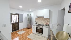 a kitchen with white cabinets and a stove at Casa de Ade in Monte da Velha