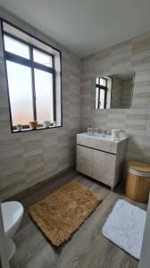 uma casa de banho com uma banheira, um lavatório e um espelho. em Casa de Ade 