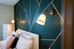 - une chambre avec un mur bleu et deux lumières au-dessus d'un lit dans l'établissement Tour Végétale CFC Cozy Anfa D, à Casablanca