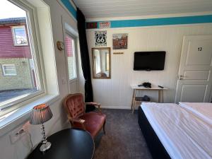 um quarto com uma cama e uma cadeira e uma televisão em Rødseth gårdsovernatting Dobbeltrom em Molde