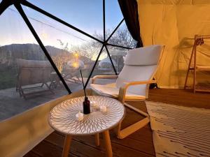 Zimmer mit einem Stuhl, einem Tisch und einem Fenster in der Unterkunft Luvinn Kayaköy in Kayakoy