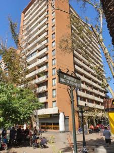 a tall building with a street sign in front of it at Departamento con excelente ubicación cerca metro los Leones in Santiago