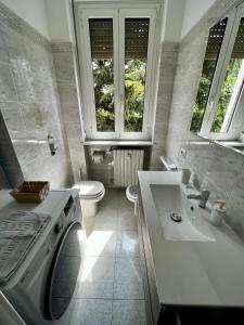 bagno bianco con lavatrice e lavandino di The Bright Place: wide and modern condo apartment in Milan a Milano
