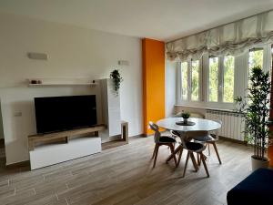 un soggiorno con TV, tavolo e sedie di The Bright Place: wide and modern condo apartment in Milan a Milano