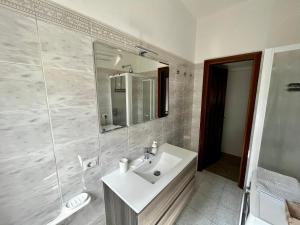 uma casa de banho branca com um lavatório e um espelho em The Bright Place: wide and modern condo apartment in Milan em Milão