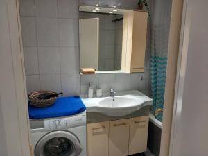 a bathroom with a sink and a washing machine at Agapi’s apartment in Thessaloniki