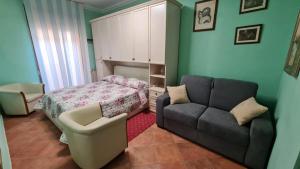 uma sala de estar com um sofá e uma cama em Al corso 2 em Naro