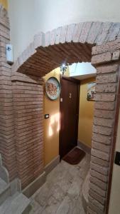 uma entrada para um quarto com uma parede de tijolos em Al corso 2 em Naro