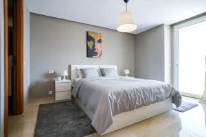 a white bedroom with a bed and a large window at Tour Végétale Luxury Anfa CFC Dalia in Casablanca