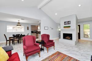 a living room with red chairs and a fireplace at Everything under 5 min. The Woodlands TX. Fully Equipped for Long stays as well. in Shenandoah