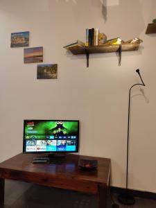 uma televisão de ecrã plano em cima de uma mesa de madeira em Il Mezzero all' Acquario em Gênova