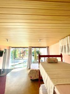 een slaapkamer met een bed en een groot raam bij Pousada Happy in São Francisco do Sul