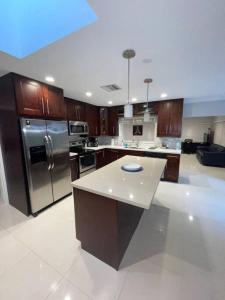 a large kitchen with stainless steel appliances and wooden cabinets at Modern Miami Oversized 3 Bedroom in Central Location in Miami