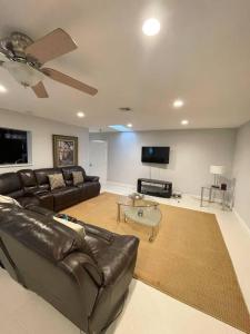 a living room with a leather couch and a flat screen tv at Modern Miami Oversized 3 Bedroom in Central Location in Miami