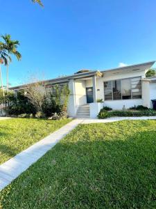 a white house with a sidewalk in front of a yard at Modern Miami Oversized 3 Bedroom in Central Location in Miami
