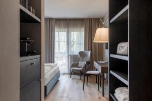 a bedroom with a bed and a desk and a chair at Hotel Magdalener Hof in Bolzano