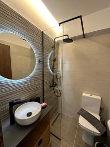 a bathroom with a toilet and a shower with a mirror at Aphrodite Holiday Home in Rethymno
