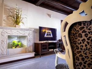 ein Wohnzimmer mit einem Kamin und einem TV in der Unterkunft Luxury house Corte dei Galati in Galatone