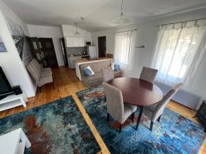 a living room with a table and chairs and a kitchen at Domek Przy Plaży in Gąski