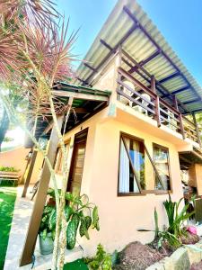 a house with a palm tree in front of it at Pousada Happy in São Francisco do Sul