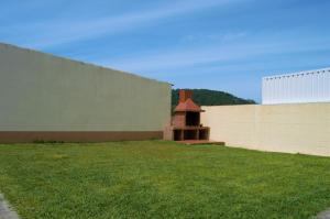 a yard with a wall and a brick fireplace at Apartamentos Son do Faro Fisterra in Finisterre