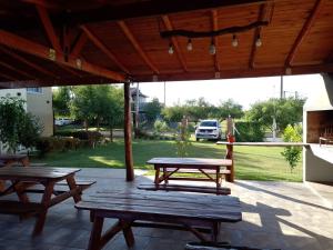 2 Picknicktische auf einer Terrasse mit geparktem Auto in der Unterkunft Apartamentos Barranca de Termas in Colón