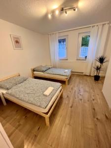 2 camas num quarto com pisos e janelas em madeira em Monteurunterkunft Simmershausen em Fuldatal