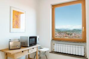 een kamer met een bureau, een televisie en een raam bij Piccapiana Sea View Attic Flat in La Spezia