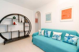 een blauwe bank in een woonkamer met een plank bij Piccapiana Sea View Attic Flat in La Spezia