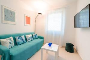 een woonkamer met een blauwe bank en een tafel bij Piccapiana Sea View Attic Flat in La Spezia