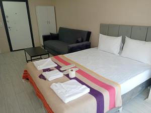 um quarto com uma cama com toalhas e uma cadeira em Ava suite em Istambul