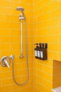 een douche in een badkamer met gele tegels bij Piccapiana Sea View Attic Flat in La Spezia