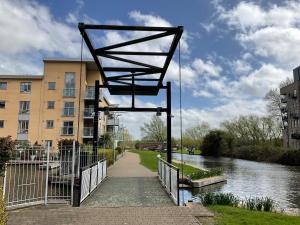 a metal structure over a walkway next to a river at Beautiful Riverview Apartment Chelmsford in Chelmsford