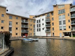 a boat in a river in front of buildings at Beautiful Riverview Apartment Chelmsford in Chelmsford