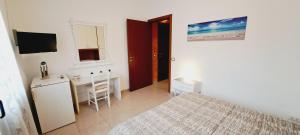 Dormitorio con cama, escritorio y TV en Le Terrazze Rooms en Ferrara