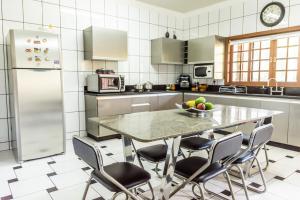 una cucina con tavolo e ciotola di frutta di Casa de campo Morada da Onça c WiFi - Capitólio - MG a Capitólio