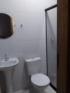 a bathroom with a toilet and a sink and a mirror at Rancho Esperança, pouso e comida a lenha in Paraty