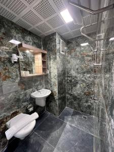 ein Bad mit einem WC, einem Waschbecken und einer Dusche in der Unterkunft Kutberk Hotel Kemer in Kemer