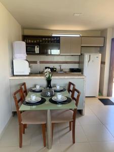 巴納內拉斯的住宿－Cond. Sonhos da Serra，一间带桌椅的厨房和一间带冰箱的厨房