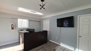 a room with a desk and a television on a wall at Newly Renovated POUSADA SUITES in Hollywood