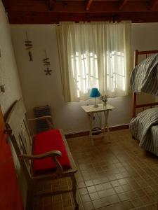 a bedroom with a chair and a table and a window at Nuestro Lugar in Villa Gesell
